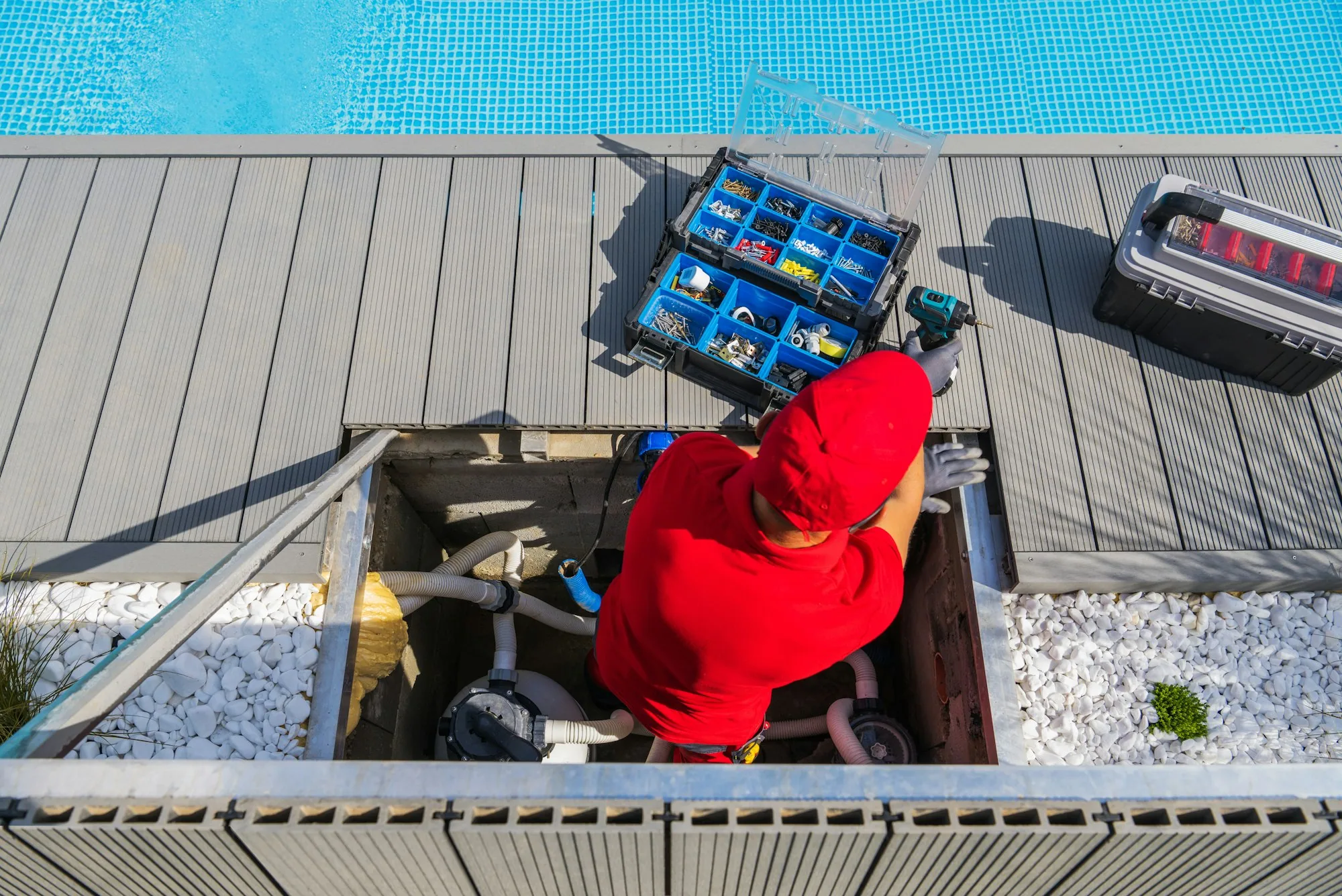 Pool technician inspecting equipment beside a swimming pool
