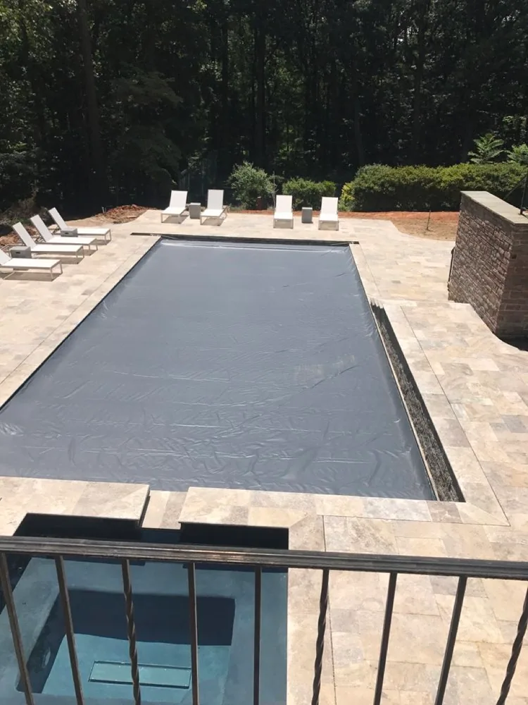 View along a covered swimming pool and its stone surround