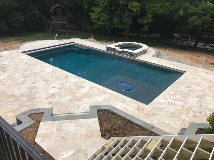 Rectangular swimming pool and raised spa set into a light stone terrace