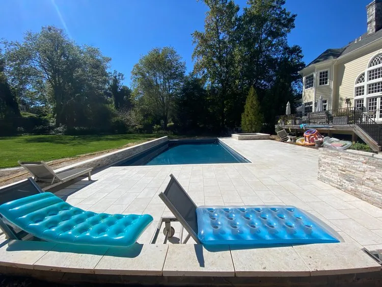 Pool and stone terrace with bright turquoise poolside lounge chairs