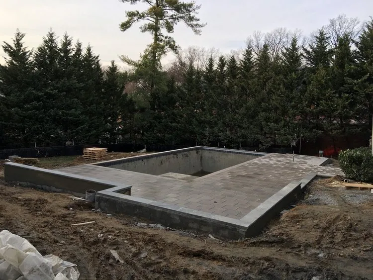 Concrete swimming pool shell under construction in a backyard